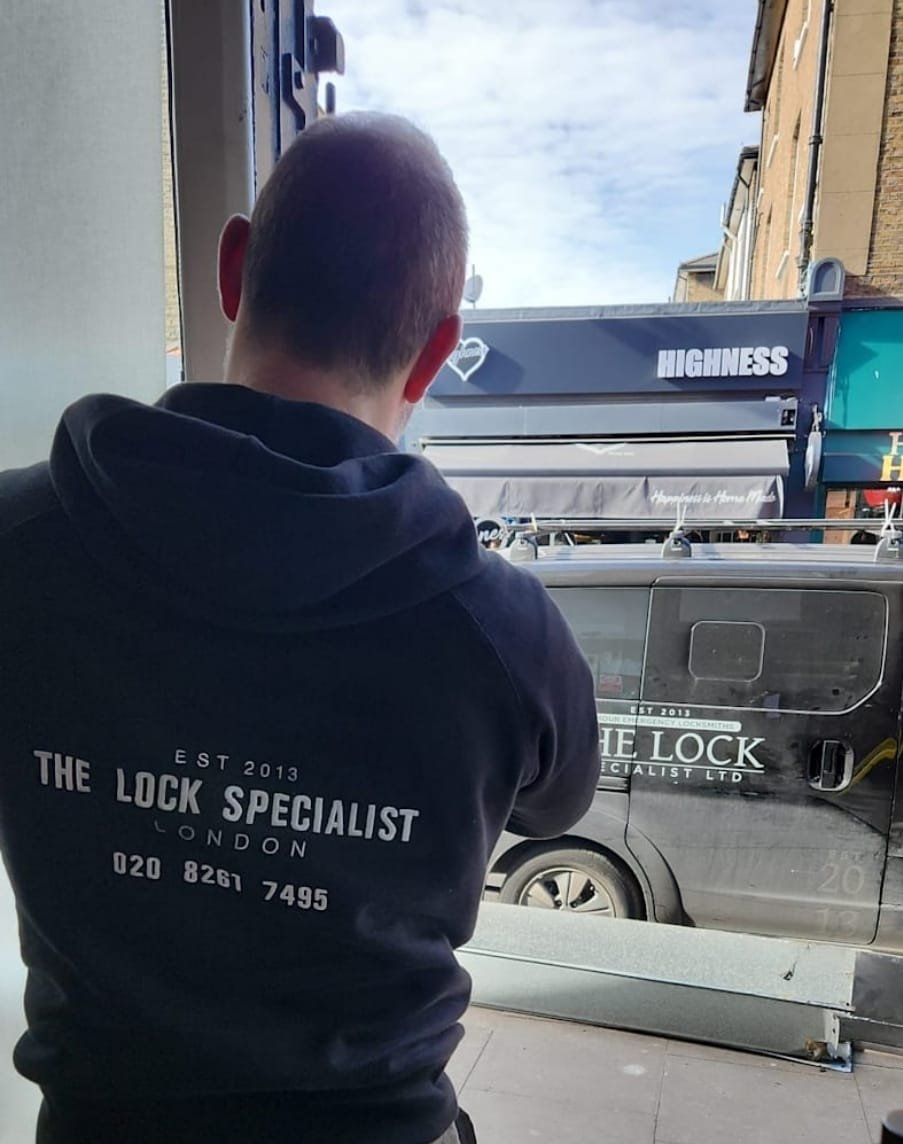 Locksmith engineer fitting a new cylinder to a front door in London